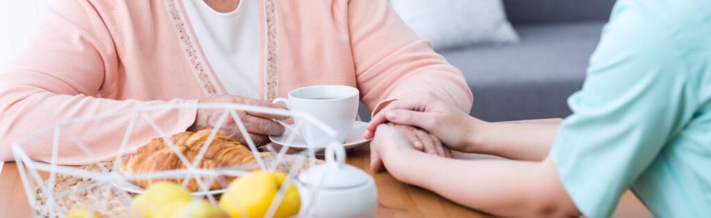 photo of nurse holding senior woman's hand